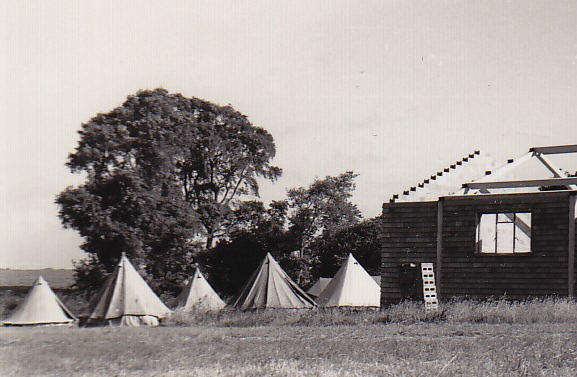 The campers slept in tents in the field at the back of the building on which they worked