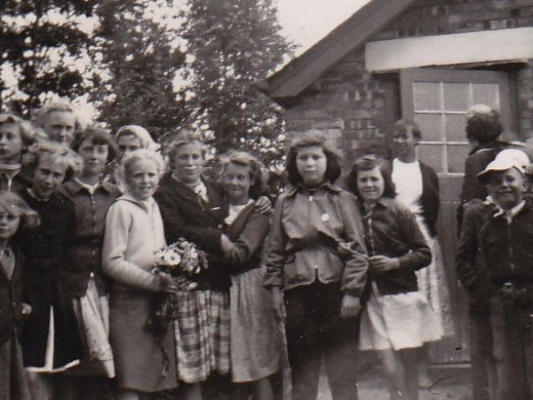 The village children arriving for the party with Karin waiting in the background,
